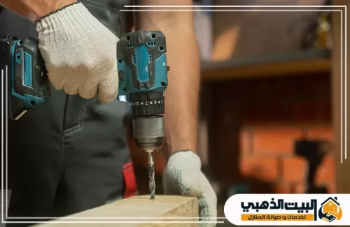 احترافية تركز على لحظة ثقب لوح خشبي سميك باستخدام مثقاب كهربائي قوي باللونين الأسود والفيروزي